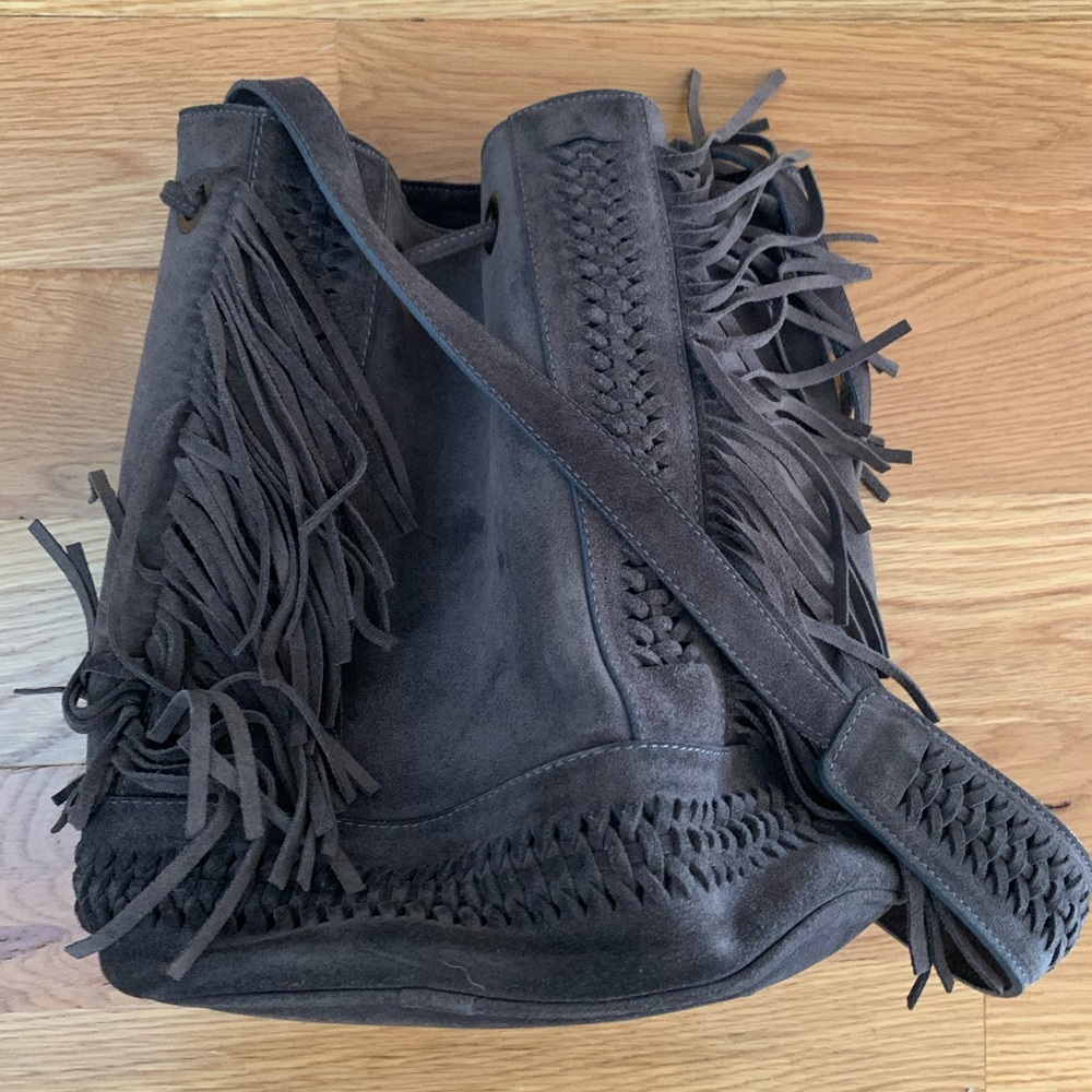 Gray suede bucket bag with fringe.